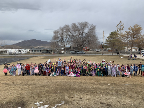 A large group of students post for a silly picture outside in their pajamas