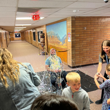 A student smiles after taking his turn with the silly string