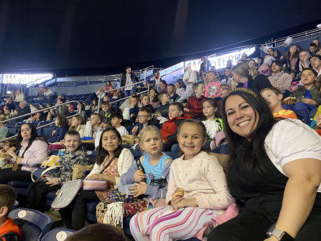 Students and chaperones smile while watching the gymnastics meet