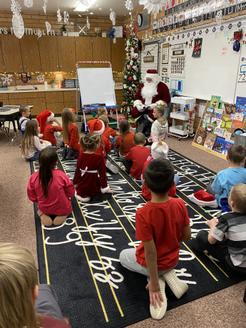 Santa reads a book to our first graders