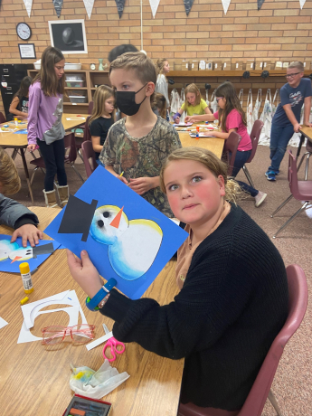 A 5th grade girl showing her snowman with the light sources