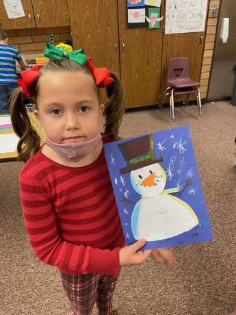 First grade girl shows off her snowman