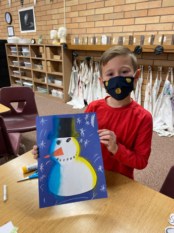 Second grade boy with his finished snowman