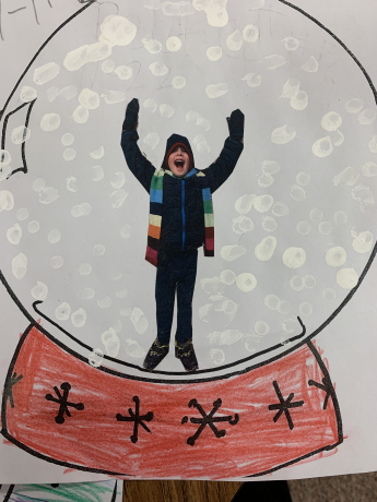 Boy with arms raised inside a snowglobe