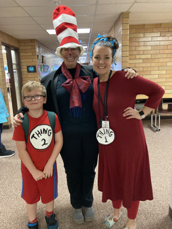 A teacher dressed as The Cat and The Hat with a teacher dressed as Thing 1 and a student dressed as Thing 2