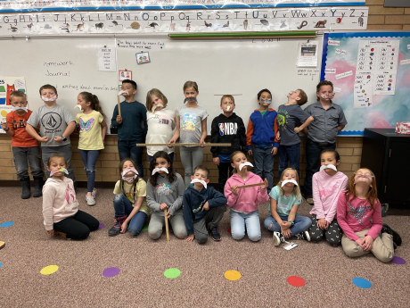 Mrs. Provstgaard's class poses with mustaches and rulers