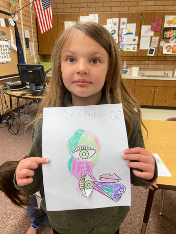 A first grade girl shows off her picture