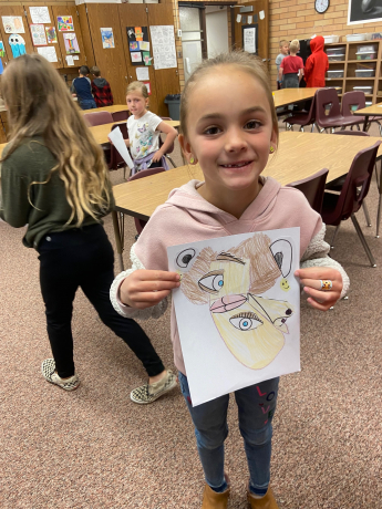 A student shows her picture she made