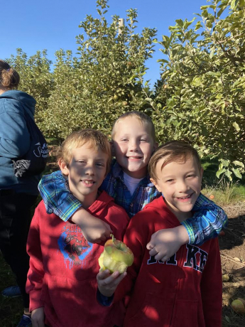 3 boys pose in the orchard