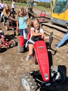A student rides on a small tractor
