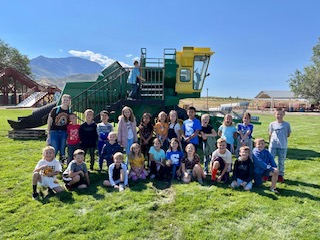 Mrs. Barnett’s class poses in front of a large green tractor