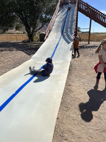 a boy slides down the giant slide
