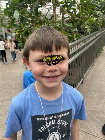 A student with a butterfly on his nose
