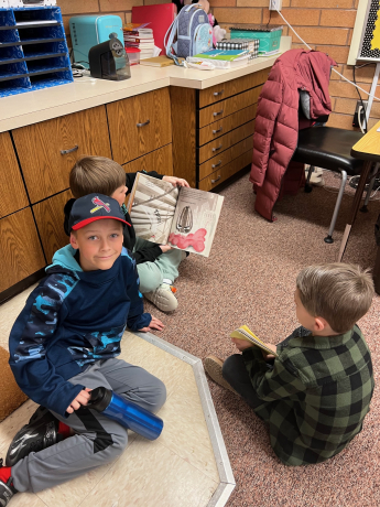 Boys show their reading buddy the pictures in the book
